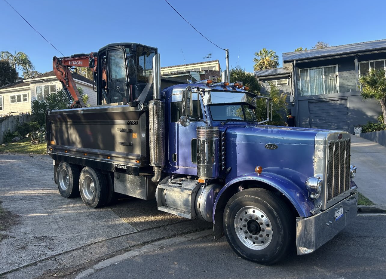 Gilcon tipper truck loaded with an excavator ready for an earthworks job